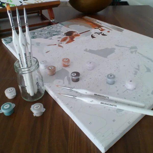 Pack Créatif BrushCrafts : peinture par numéros sur toile, pots de peinture numérotés et 5 pinceaux de précision posés sur une table en bois